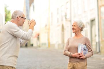 senior couple photographing on city street