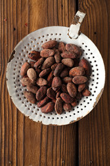 roasted cocoa chocolate beans in old enamel sieve, textured  woo