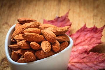 Almonds in bowl on autumnal background
