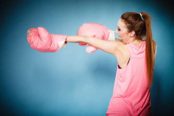 Female boxer wearing big fun pink gloves playing sports