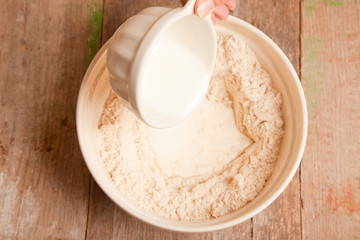 pouring milk in to flour