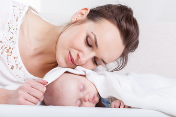 Obraz na płótnie Canvas Sleeping infant and attractive mum