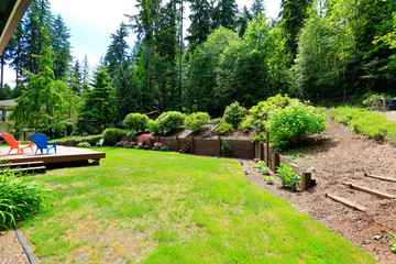 House with wooden patio area overlooking backyard landscape