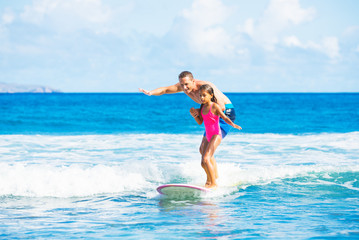 Fototapeta na wymiar Father and Duaghter Surfing Together