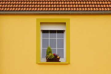 Renovierte Fassade mit PVC Fenster, Rollladen und Blumenschmuck