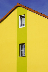 Fototapeta na wymiar Renovierter Hausgiebel mit PVC Fenstern und Malerdekor