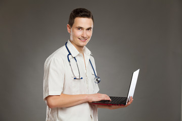 Smiling male nurse posing with laptop