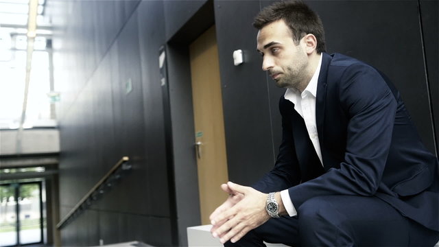 Handsome man waiting for job interview sitting on chair