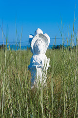 white buddha status in grass fiekd on blue sky background
