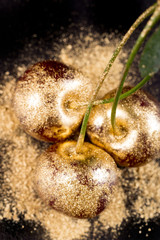 Gold fruits on black background close up 