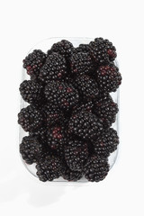 Brombeeren im Platikschälchen  auf weissem Untergrund