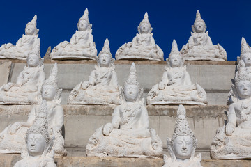 Fototapeta na wymiar raw of white buddha status on the wall