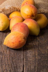 Apricots with sack cloth on wooden table 