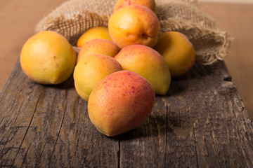 Apricots with sack cloth on wooden table 