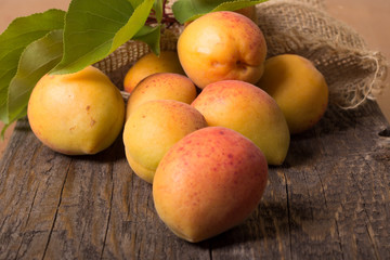 Apricots with sack cloth on wooden table 