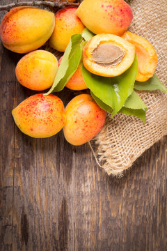 Apricots with sack cloth on wooden table 