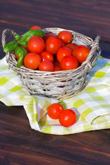 Tomatoes with basil in basket outdoors