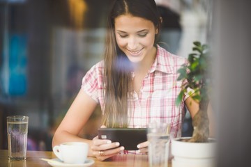 Young woman in cafe looking in tablet