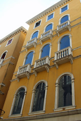 Fototapeta premium yellow facade with blue window of a prominent Venetian Palace in