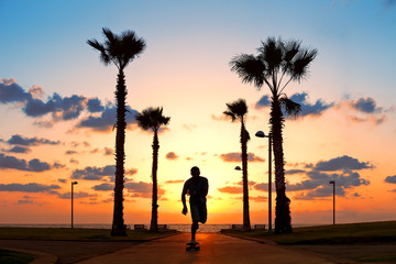 man riding on skateboard near the ocean in sunset © Alex from the Rock