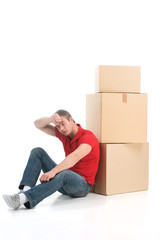 male sitting on floor tired of moving boxes.