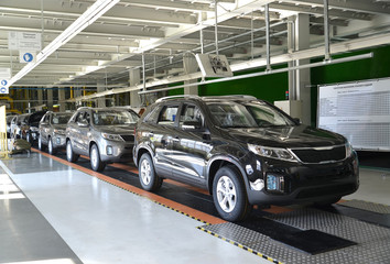 Ready cars stand on the conveyor line of assembly shop. Automobi