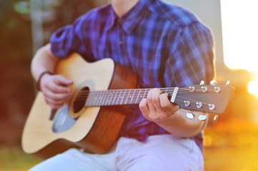 Close up portrait of male hands playing acoustic guitar