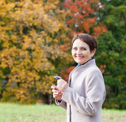 attractive woman 50 years in the autumn park