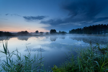 misty sunrise on river in summer