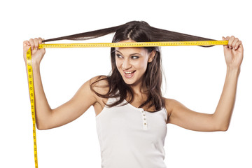 Happy attractive girl measured her hair with a tape measure