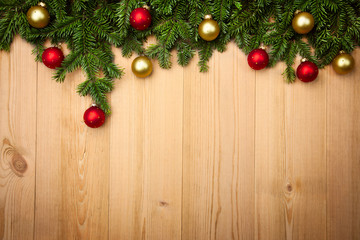 Christmas background with firtree and baubles on wood