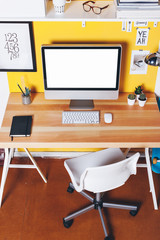 Modern creative workspace on yellow wall.