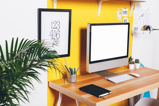 Modern creative workspace on yellow wall.