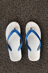 Old sandals on the grey carpet