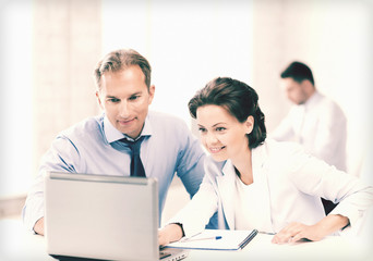 man and woman working with laptop in office