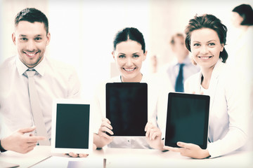 business team showing tablet pcs in office