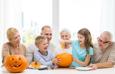 happy family sitting with pumpkins at home