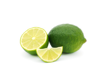 Limes with slices and leaves isolated on white background