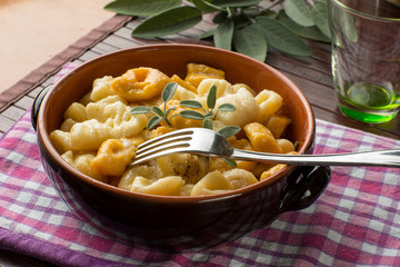 Gnocchi di ricotta e di zucca misti nel tegame di coccio