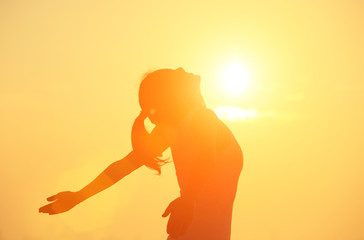 woman open arms under the sunrise at sea 
