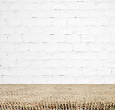Sackcloth over table and white brick wall, background, template