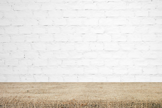 Sackcloth over table and white brick wall, background, template
