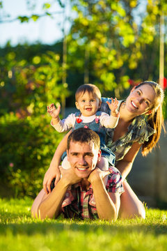 Happy young family having fun outdoors in summer. 
