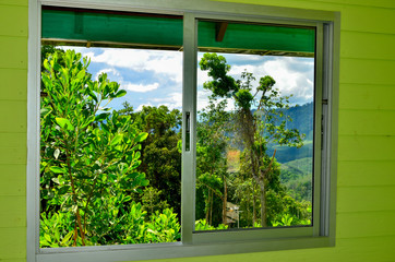 Summer field and mountains seen through the window