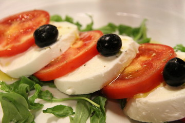 Mozzarela cheese fresh tomatoes and black olives