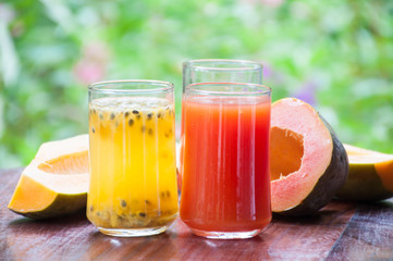 Papaya juice on wooden table with flower garden background