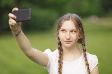 teenage girl taking selfie on smartphone