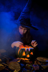 The little witch with halloween pumpkin
