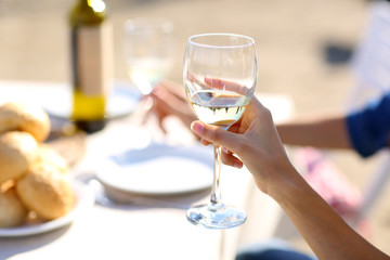 Obraz na płótnie Canvas Friends enjoying drink at outdoor restaurant. Hand with glass,