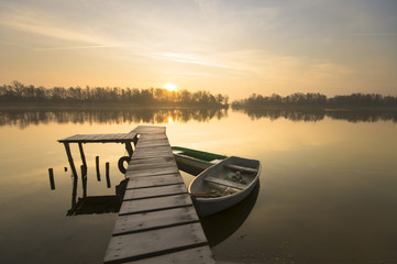 Fototapeta premium Łodzie wędkarskie zacumowane przy pomoście nad jeziorem